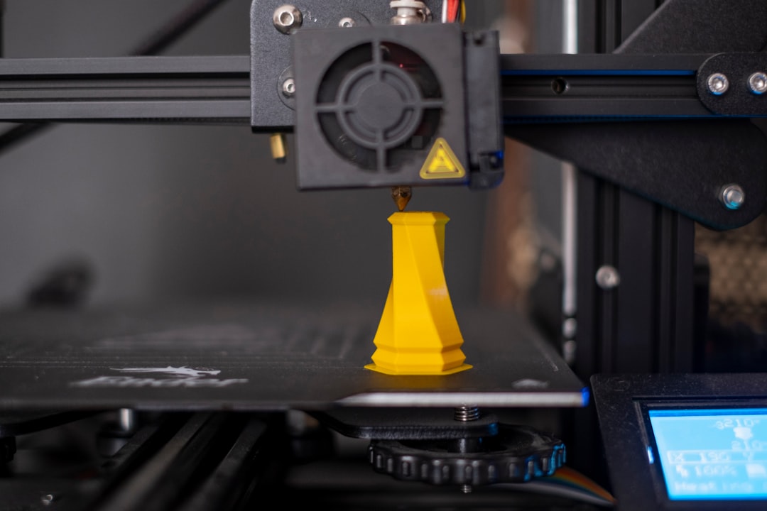 Close-up of a 3D printer nozzle during printing showing the layer transition point