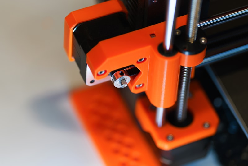 Close-up of 3D printer mechanism showing motor and rail assembly